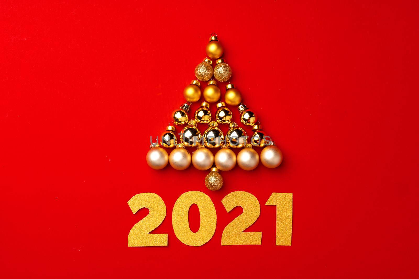 Christmas tree made of gold baubles on red background top view