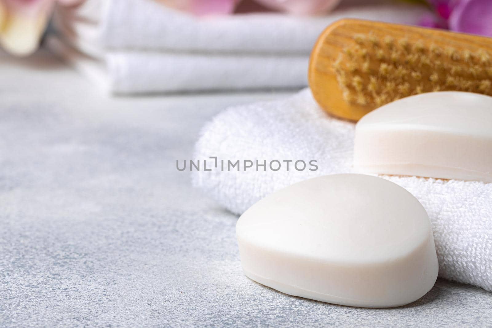 Bar of natural handmade soap, towel and spa objects, close up
