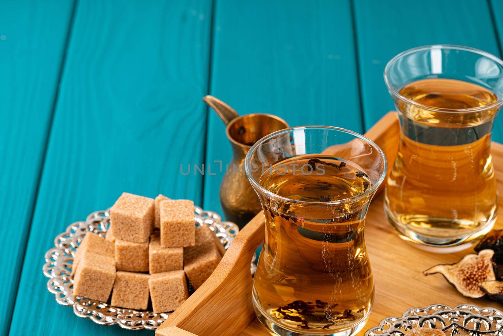 Turkish gllass cup of tea served with desserts on table, close up