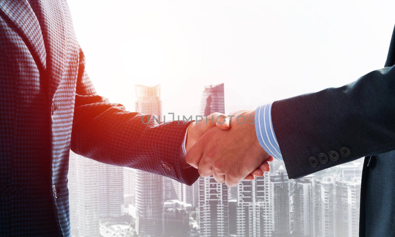 Close-up of the handshake of businessmen. Against the backdrop of the cityscape