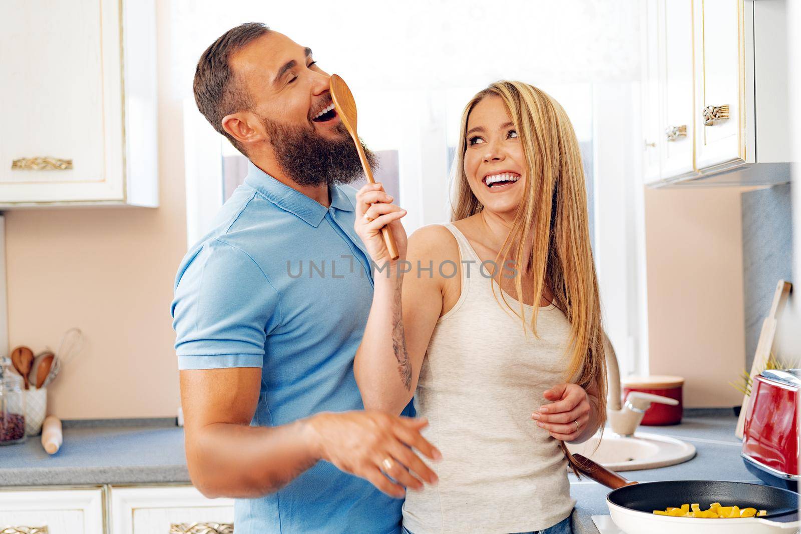 Young loving couple cooking together in kitchen at home