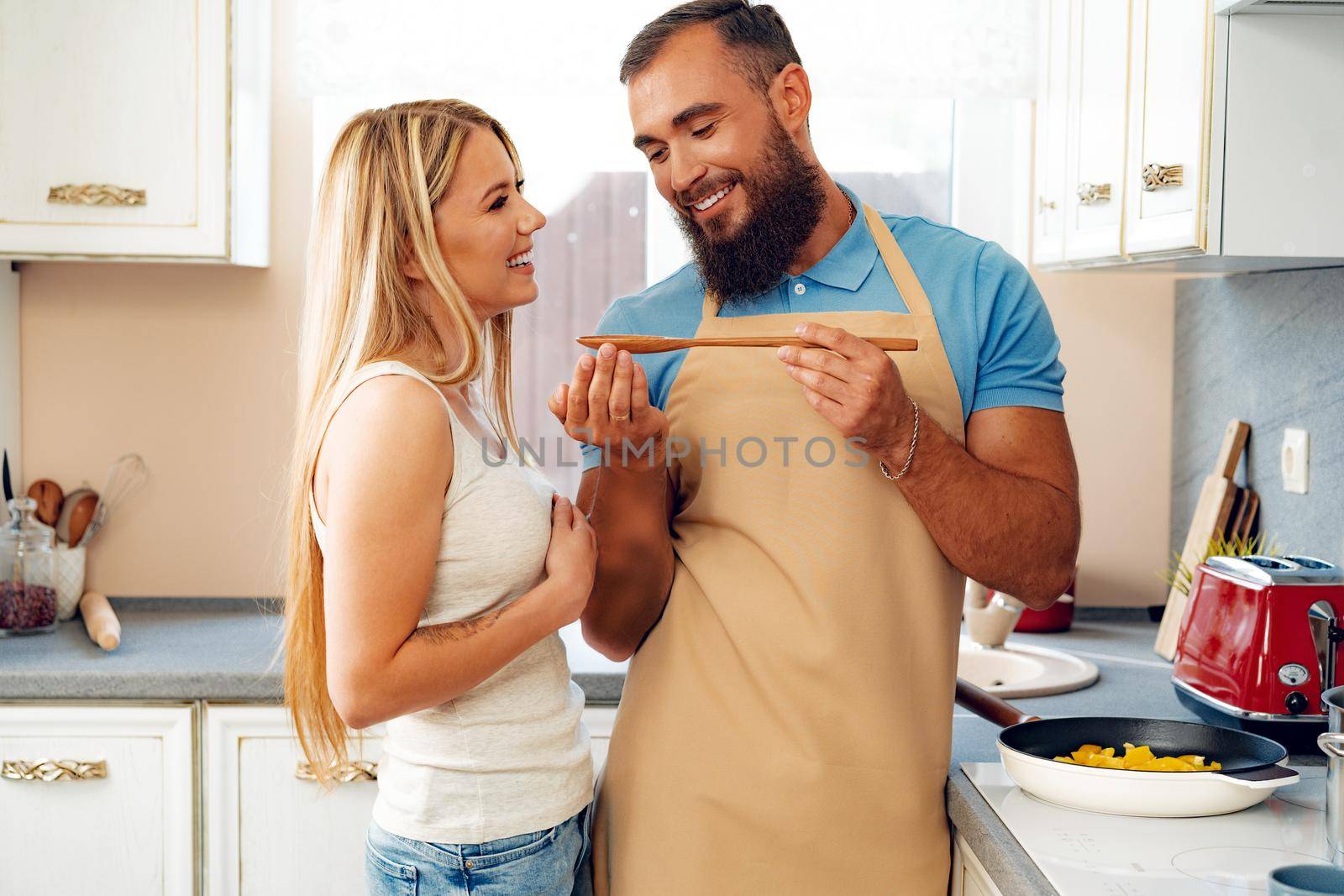 Young loving couple cooking together in kitchen at home