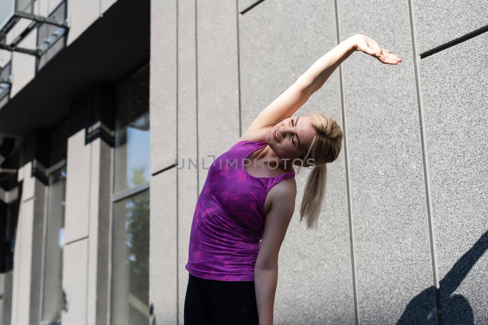 Sport woman doing stretching exercise during outdoor cross training workout