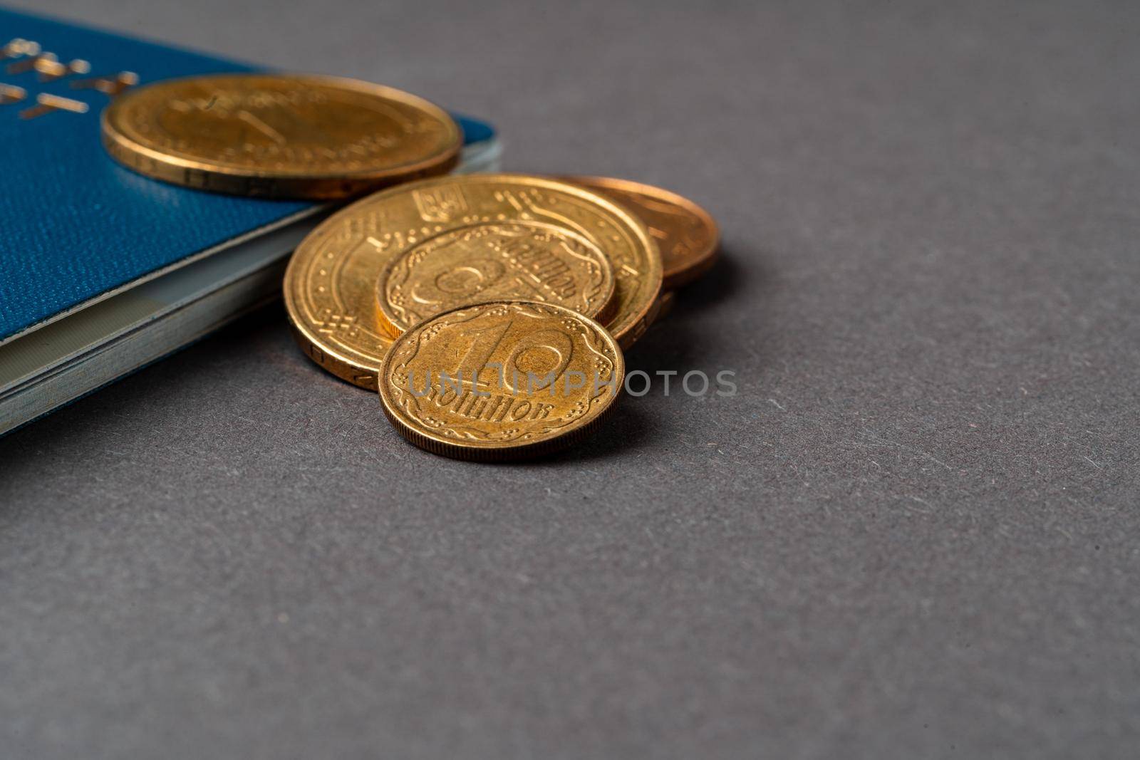 Ukrainian passport with ukrainian hryvnia coins. Poverty and immigration concept. High quality photo