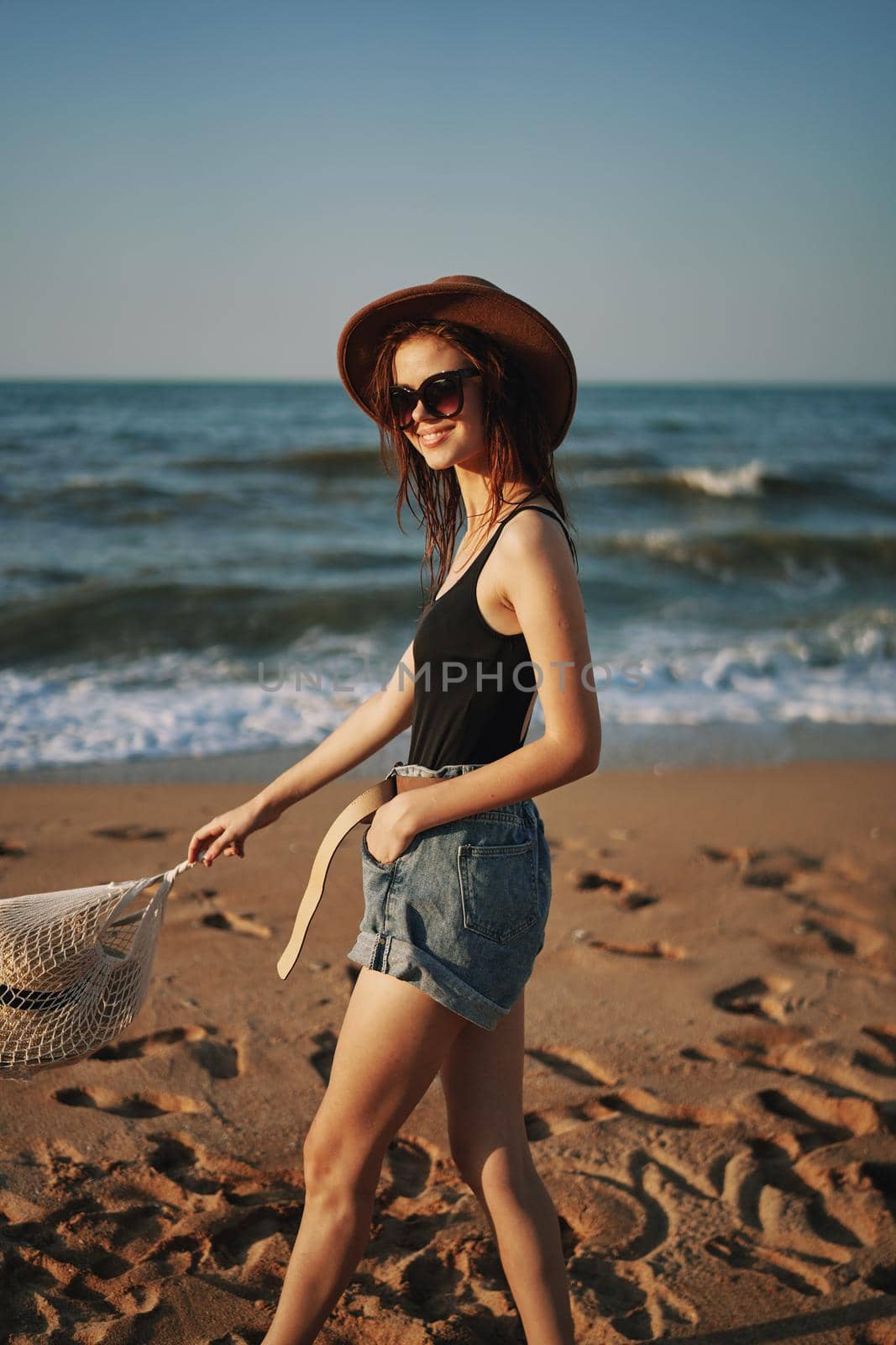 pretty woman in hat walking on the beach ocean travel. High quality photo