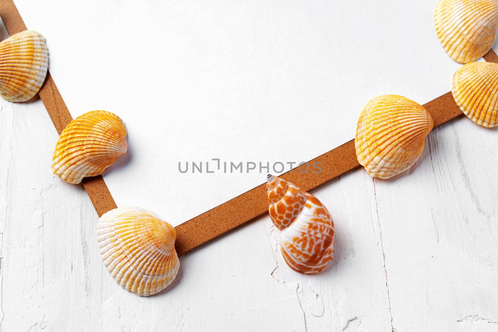 Clipboard with sea shells on white wooden table close up, copy space.