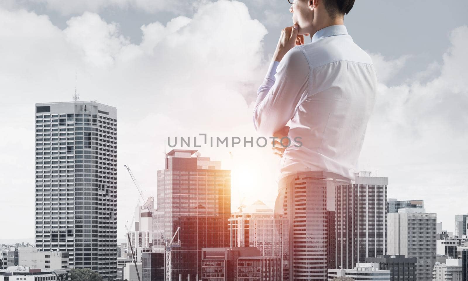 Double exposure of elegant businessman with hand on chin looking away