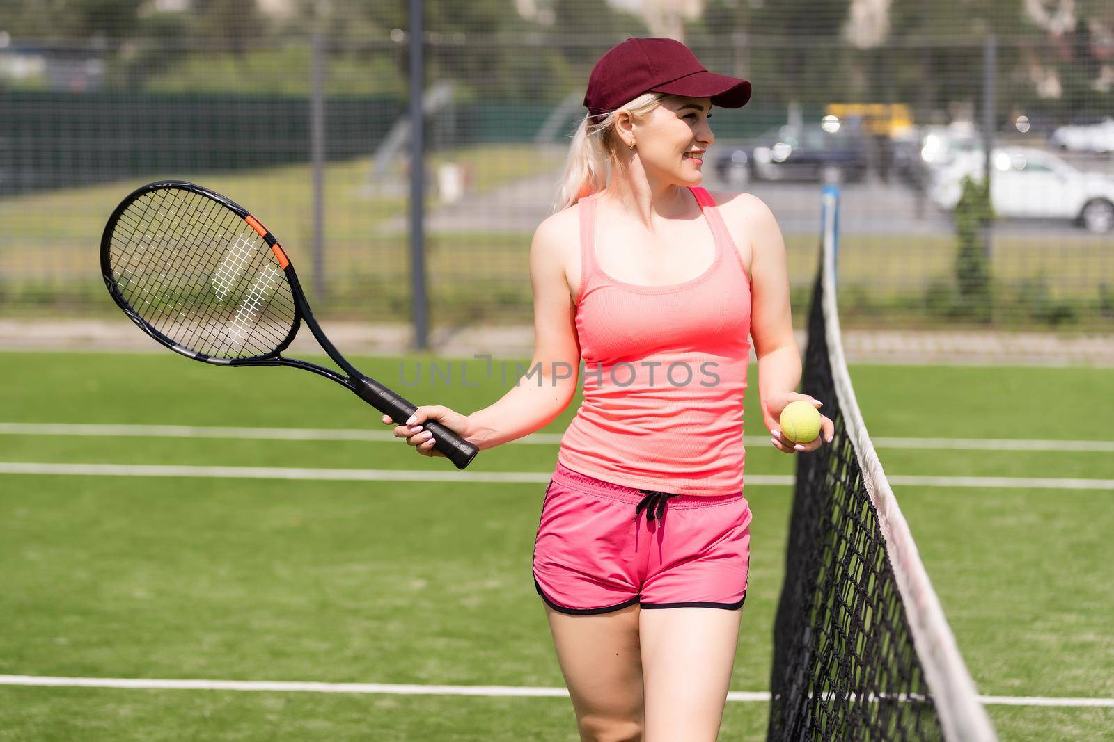 Woman playing tennis holding a racket and smiling by Andelov13