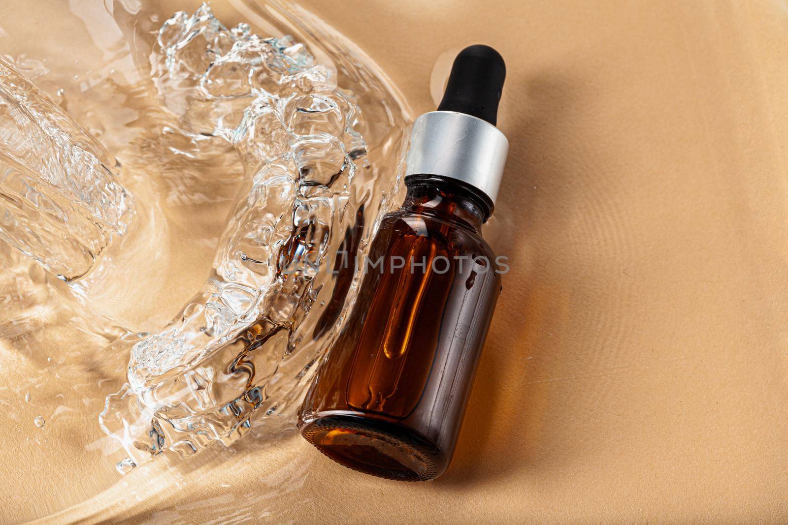 Oil cosmetic bottle on water waves background, top view