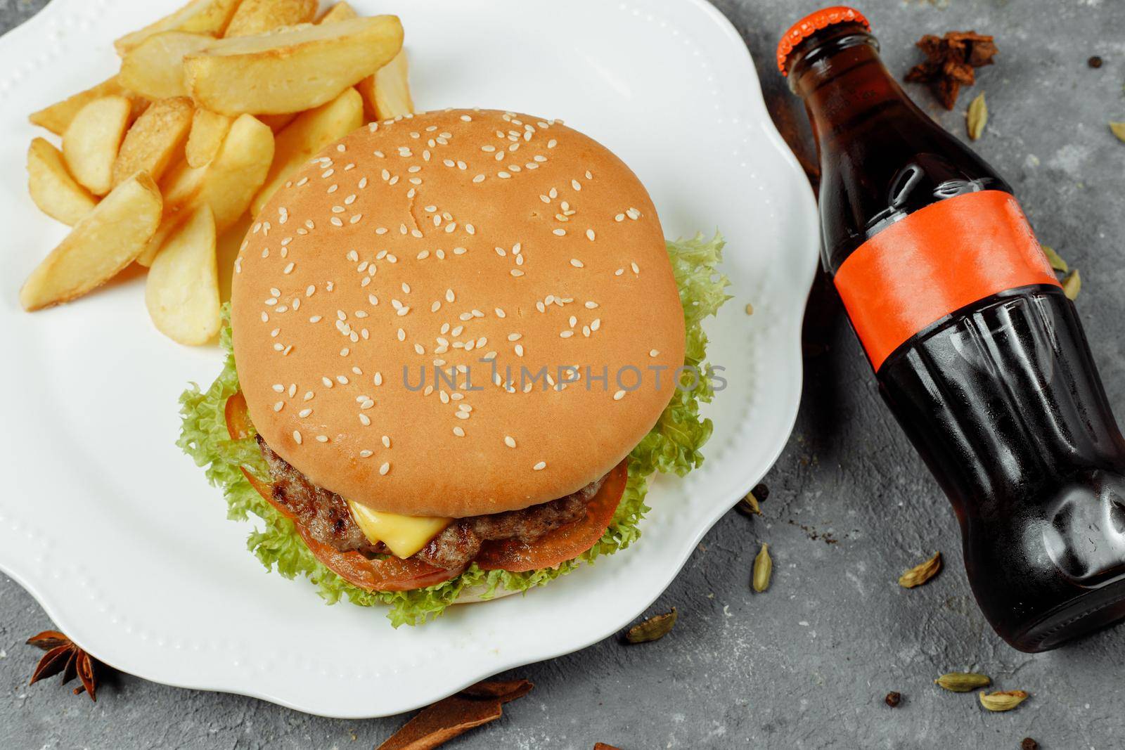 hamburger with fries and salad on the plate.