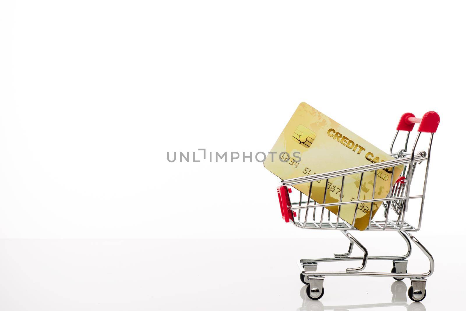 Shopping cart with credit card and copy space on white background - image