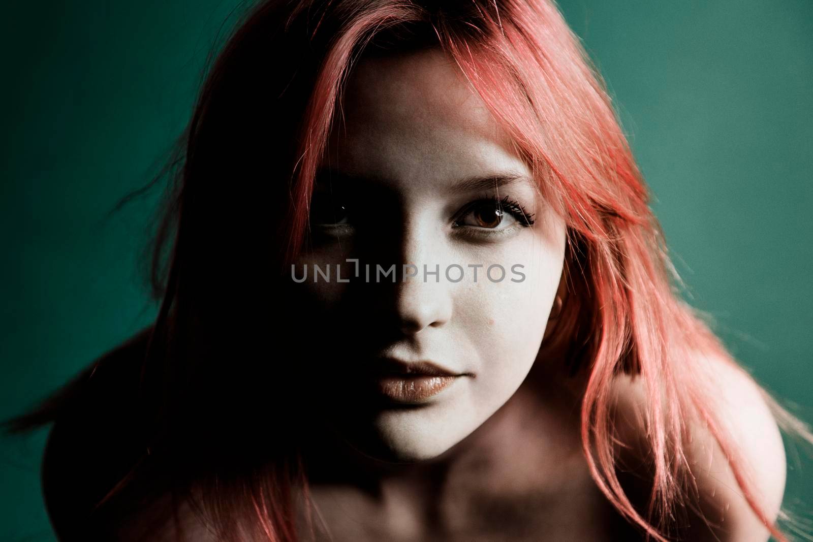 Pretty Young redhead girl on a green background