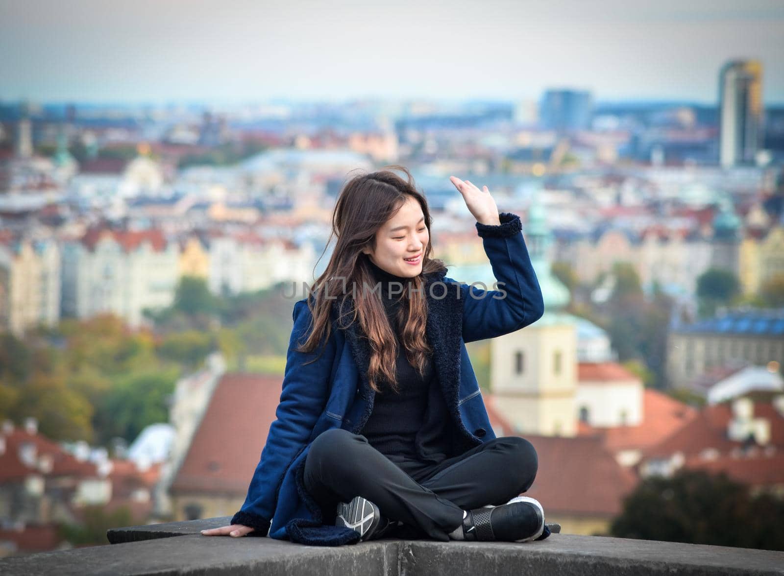 Prague, Czech Republic - October 10, 2017: Pretty girl poses and looks at the old city of Prague from observation decks near Prague Castle, Prague Czech Republic