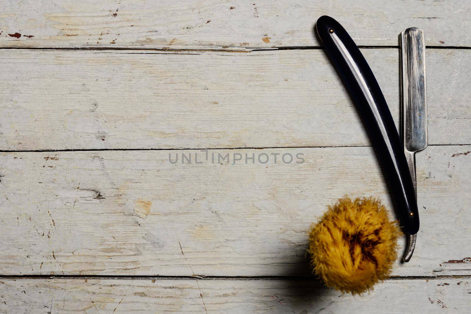 Straight Razor and shaving supplies on wooden background