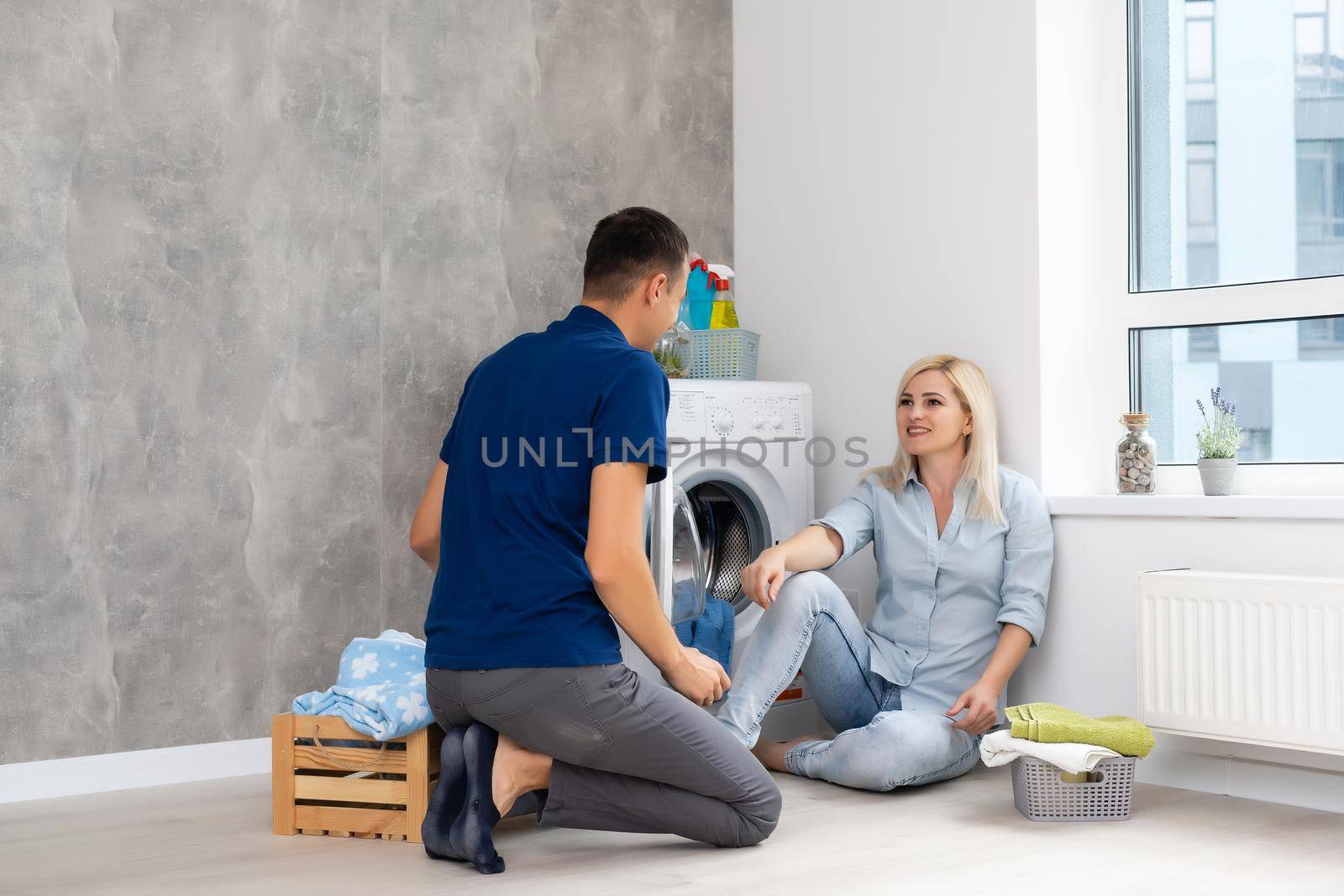 man and woman with washing machine in apartment