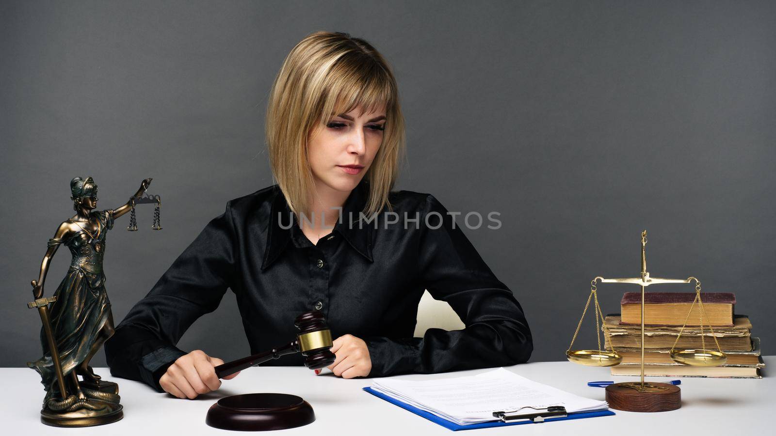 A young fair woman judge works in her office. - image