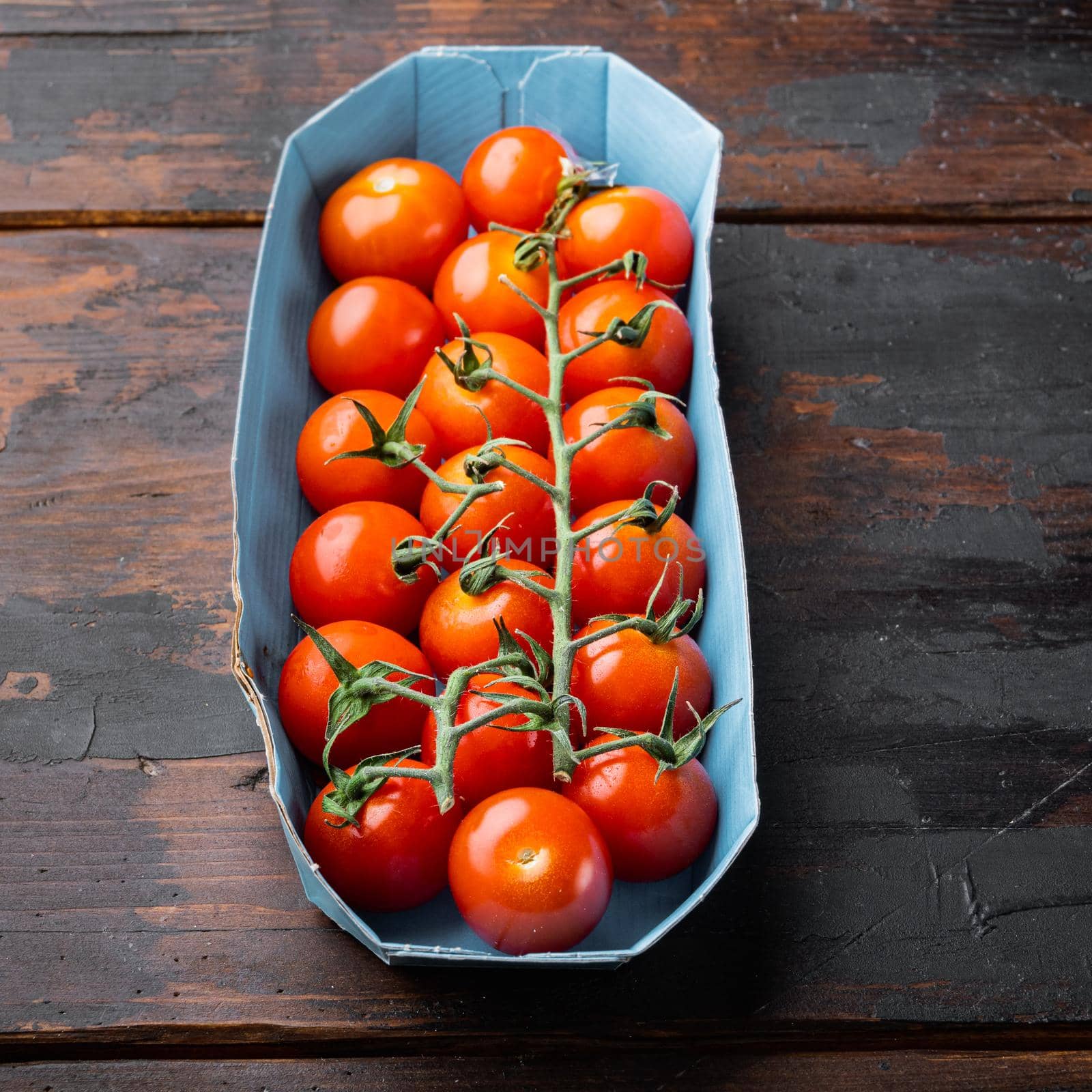 Fresh red organic cherry tomatoes, on dark wooden background