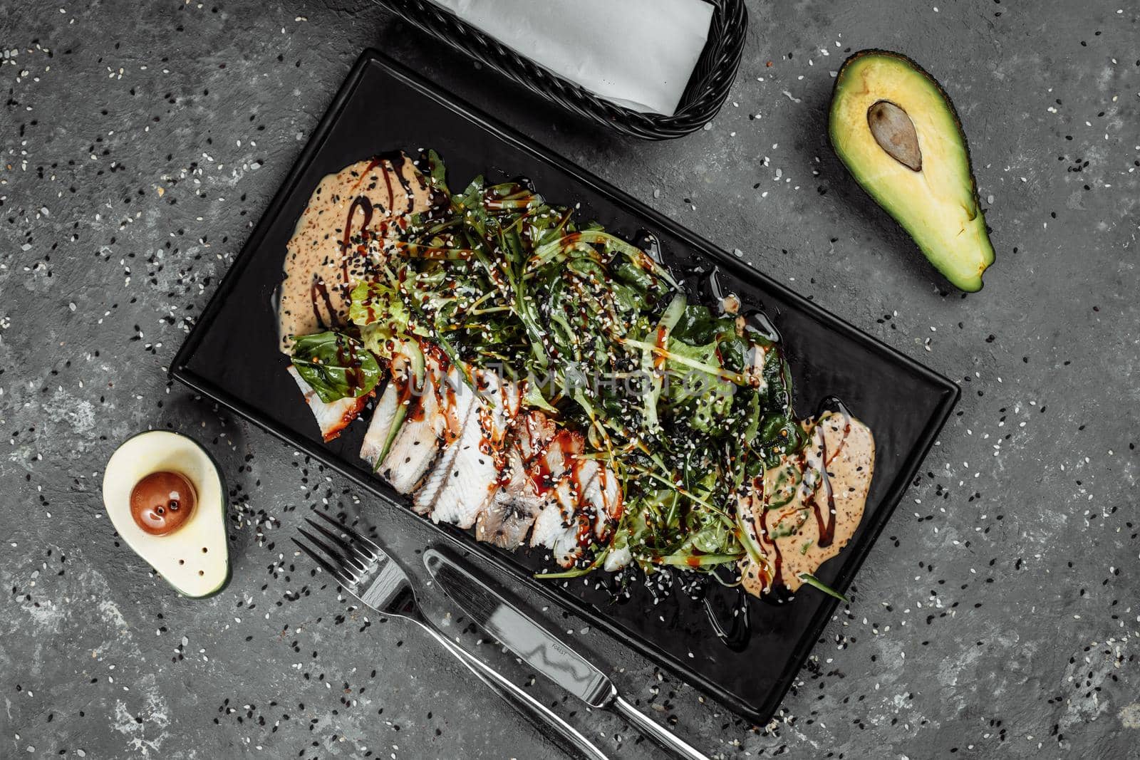 Green salad with smoked eel fish, oranges and avocado slices. Flat lay. Japanese cuisine.