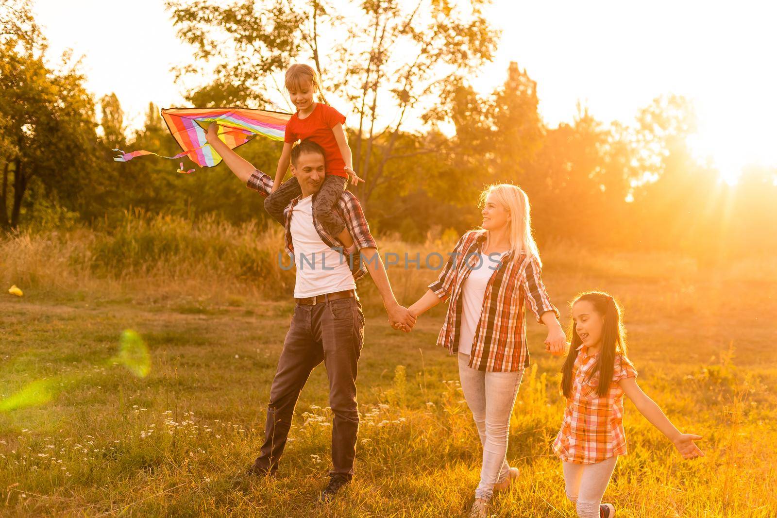 Happy family walking in field and looking at sunset