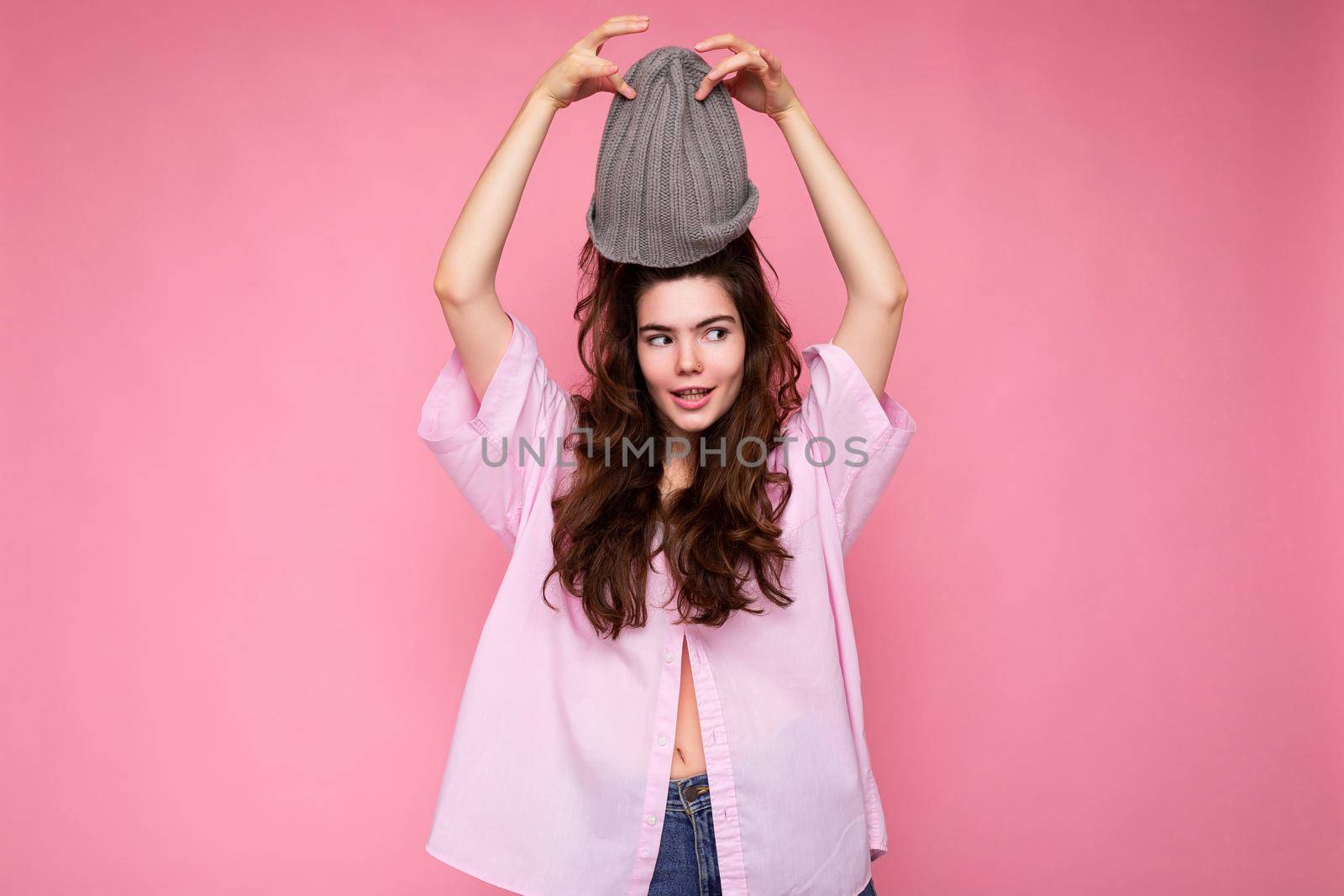 Beautiful positive happy young brunette woman isolated over colourful background wall wearing casual stylish clothes feeling sincere emotions looking to the side by TRMK