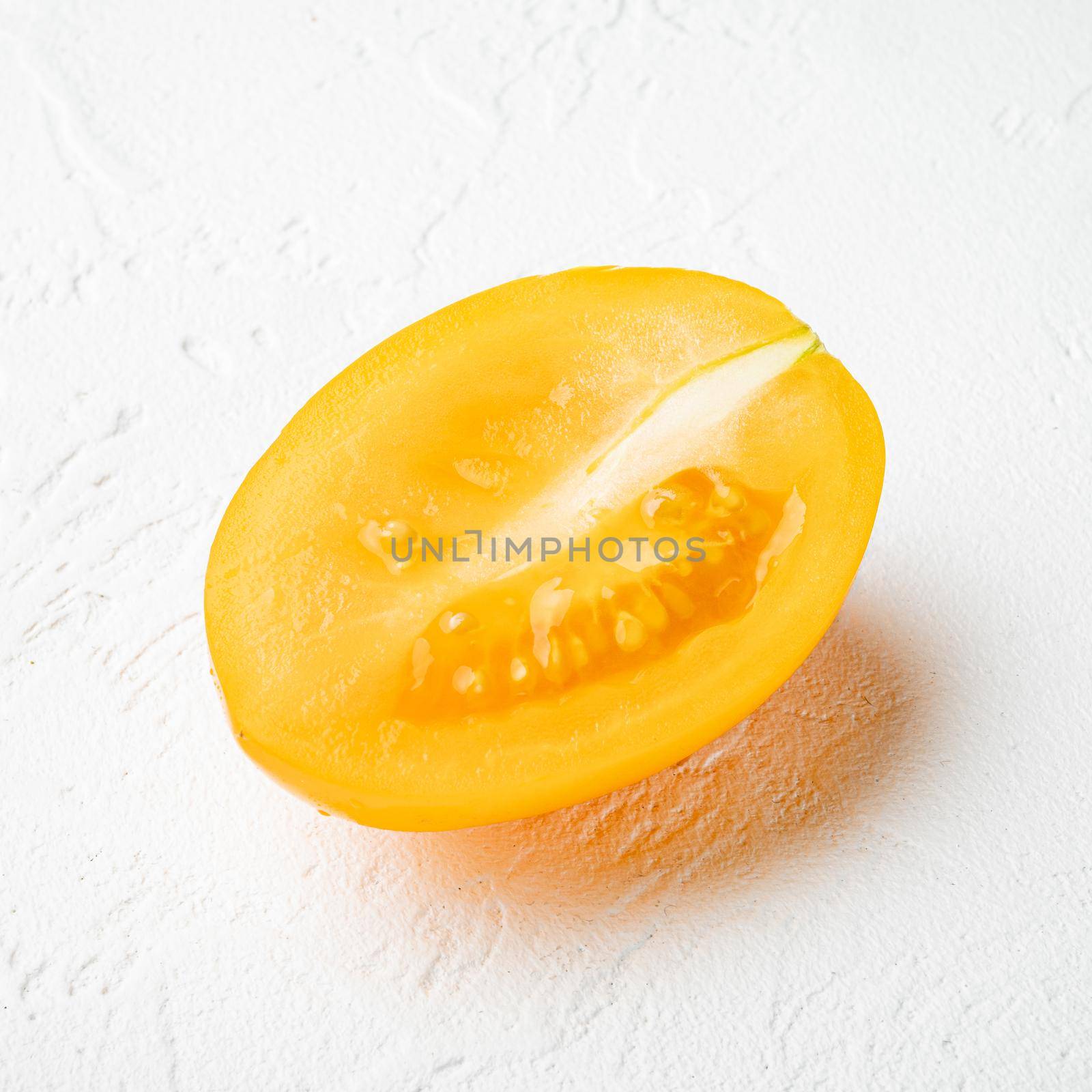 Ripe Yellow plum tomatoes, on white stone table background, square format by Ilianesolenyi