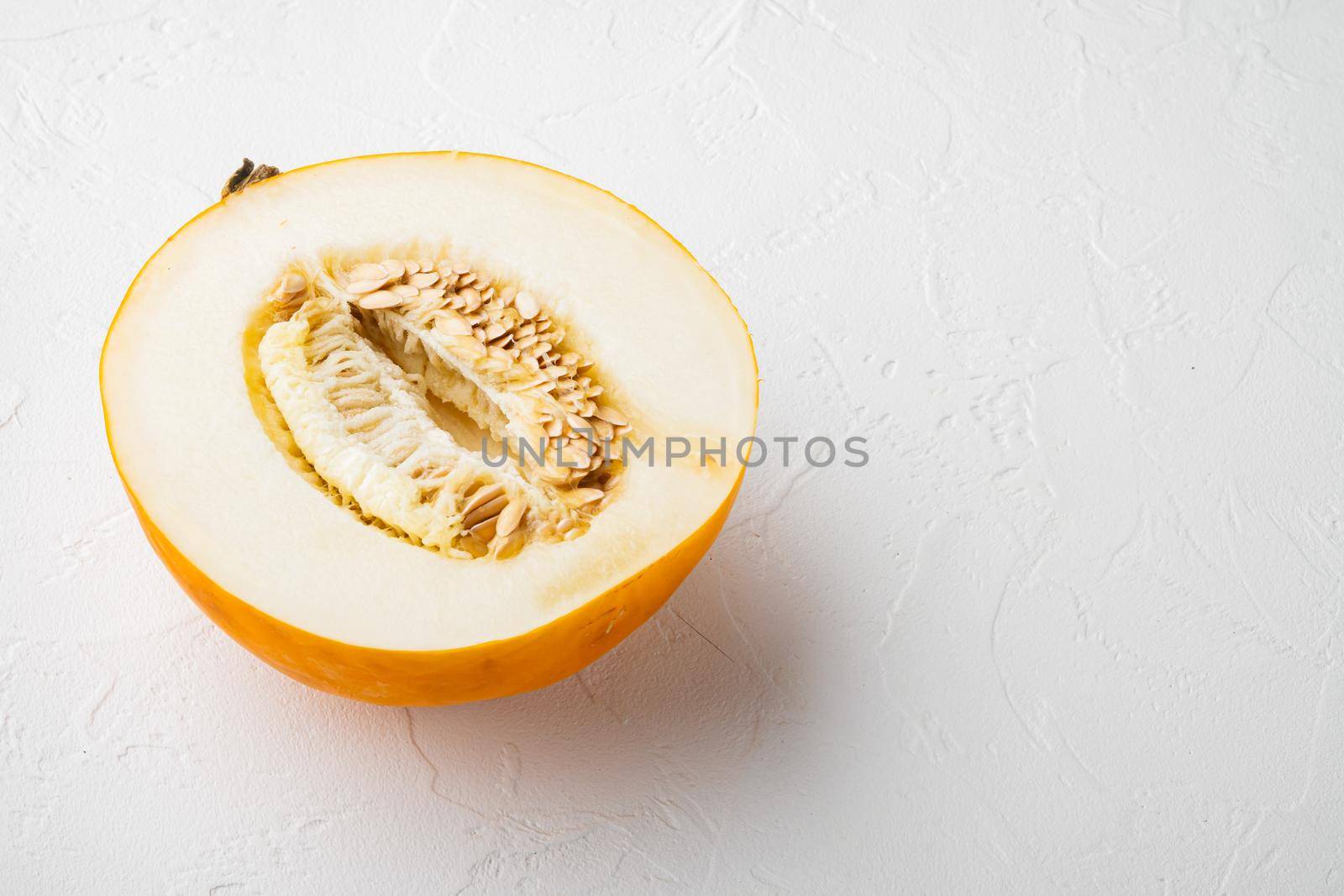 Half of cantaloupe melon set, on white stone table background, with copy space for text