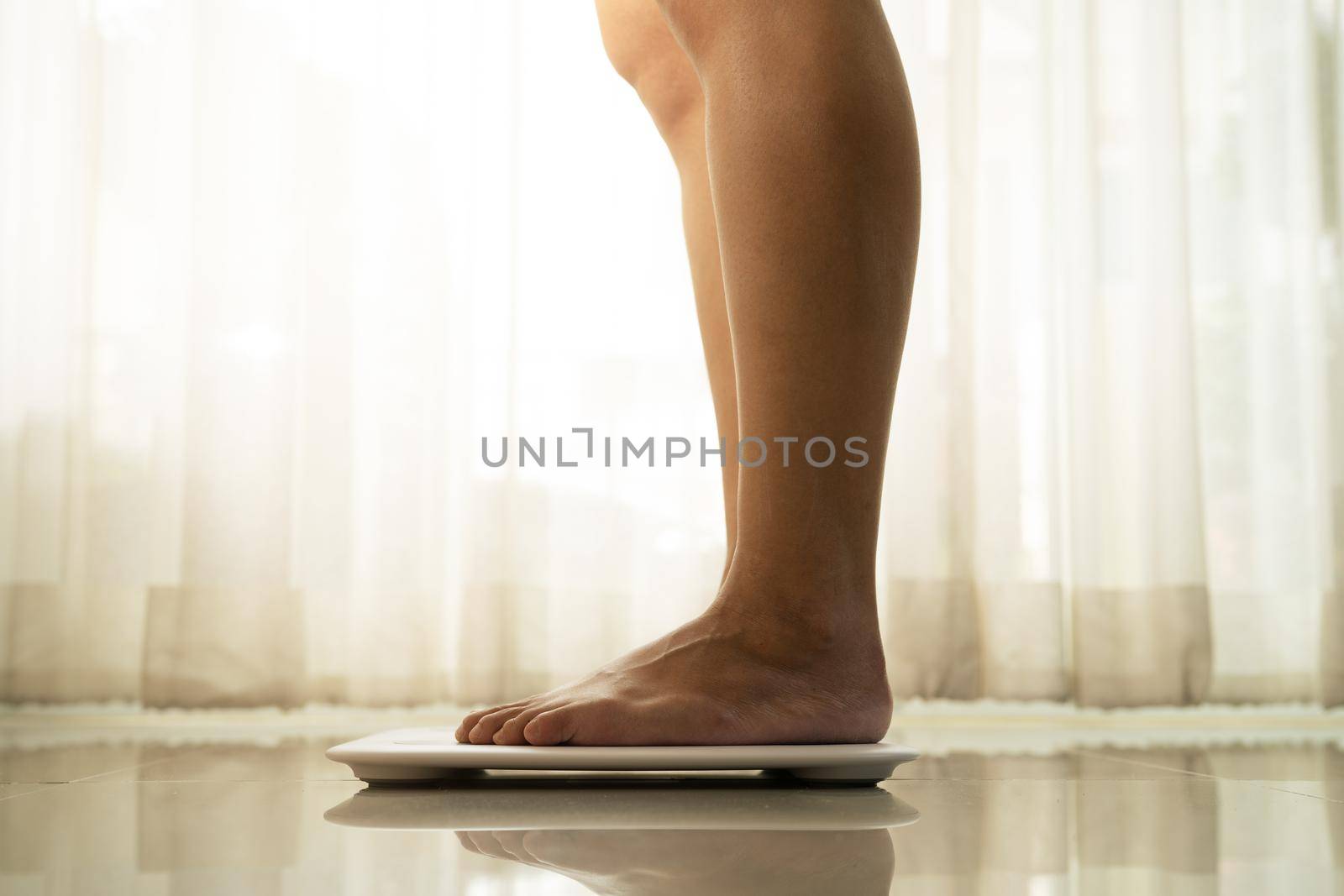 young woman standing on digital weight scale by psodaz
