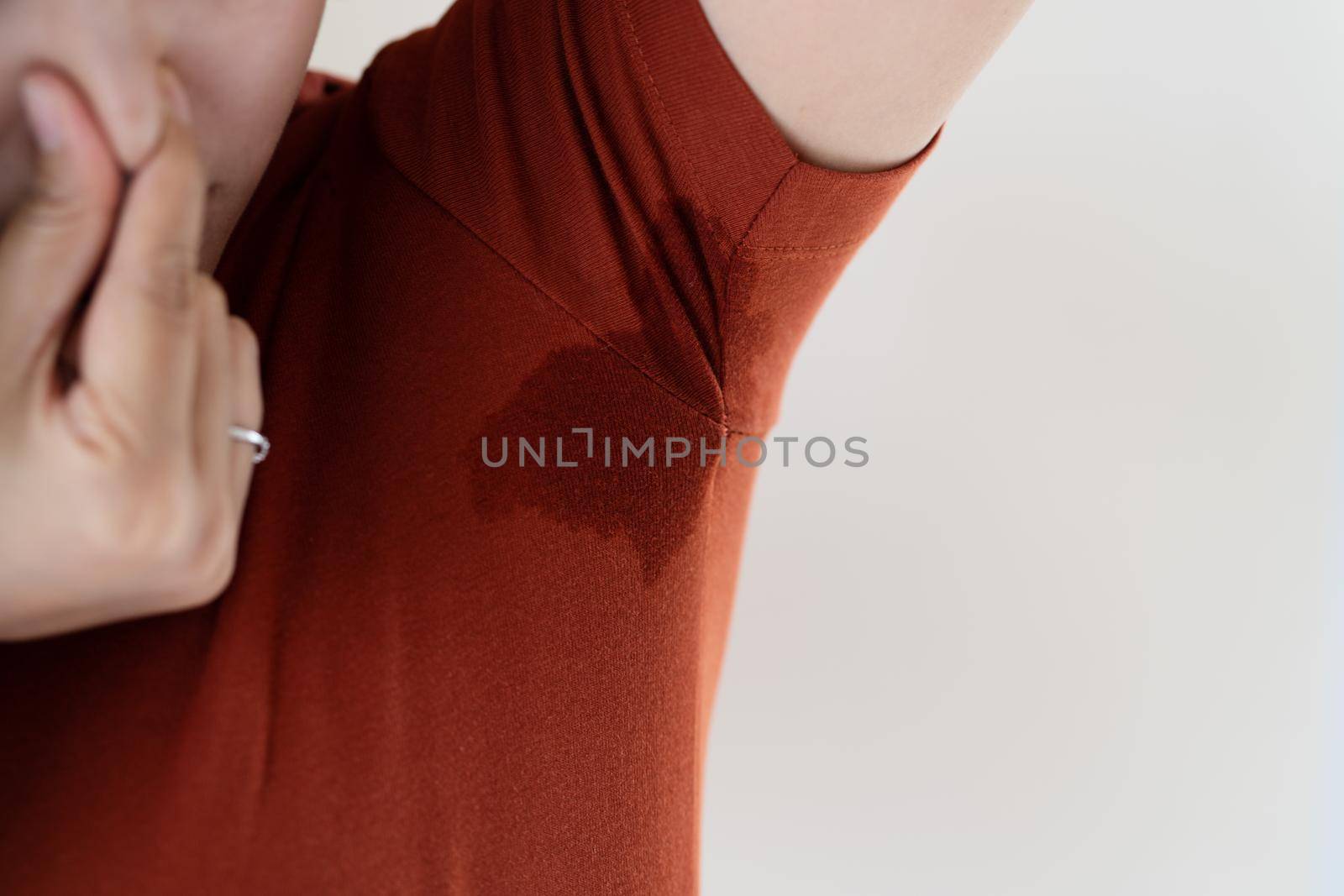 woman with hyperhidrosis sweating. Young Asia woman with sweat stain on her underarm clothes. Healthcare concept by psodaz