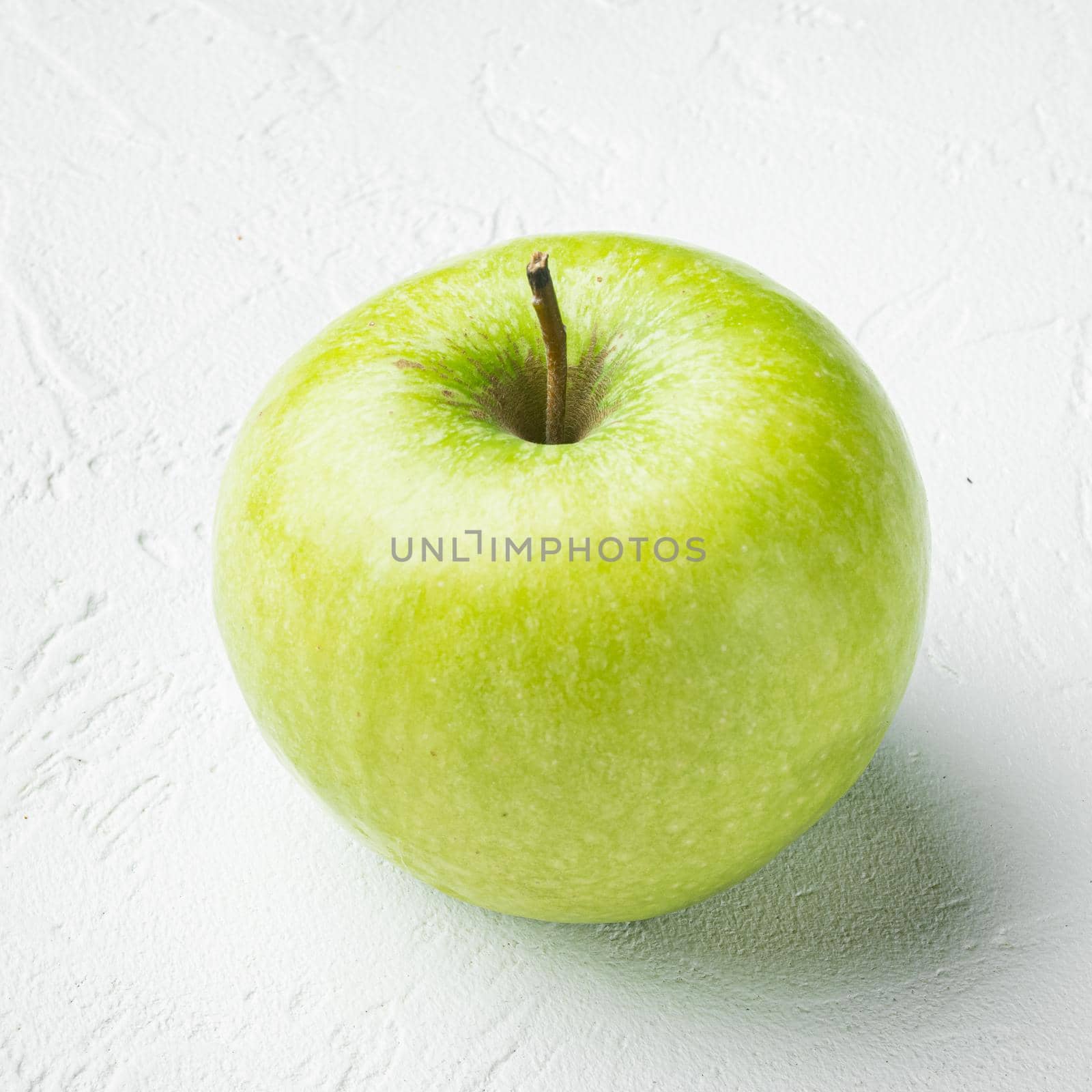 Granny smith apple, on white stone table background, square format by Ilianesolenyi