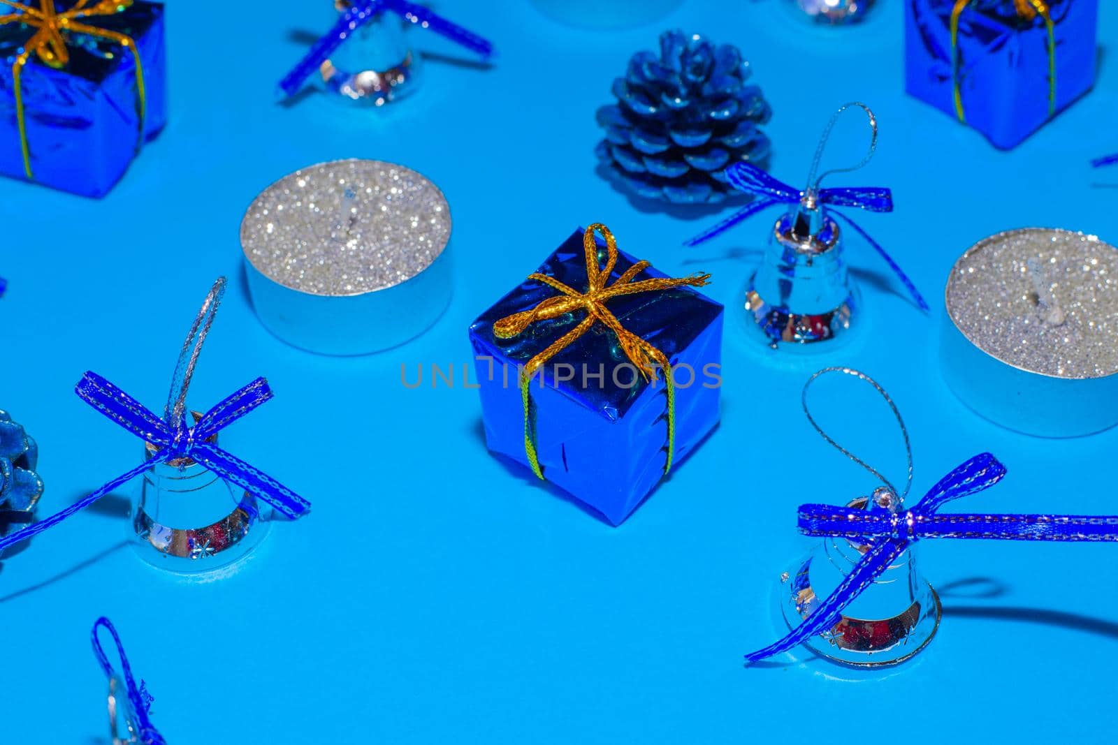 candles and christmas decorations on blue background, christmas festive background, blurred focus by levnat09