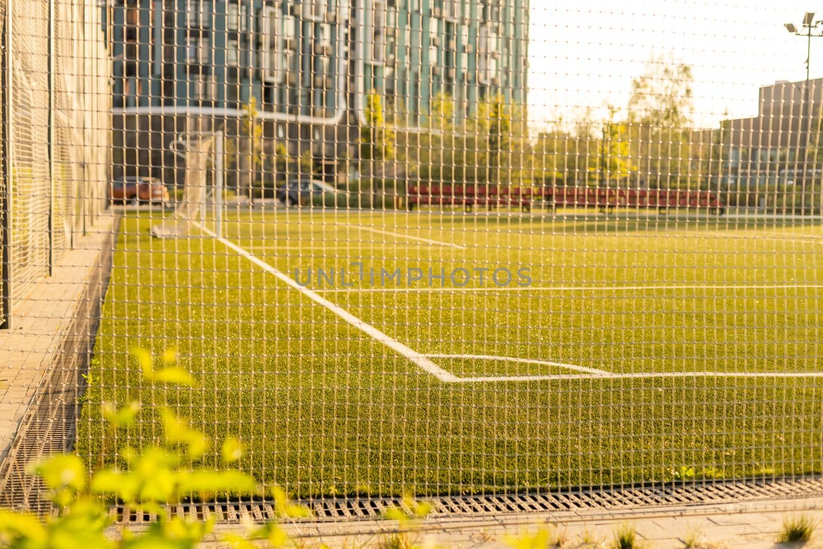 Soccer or football net background, view from behind the goal with blurred stadium and field pitch.