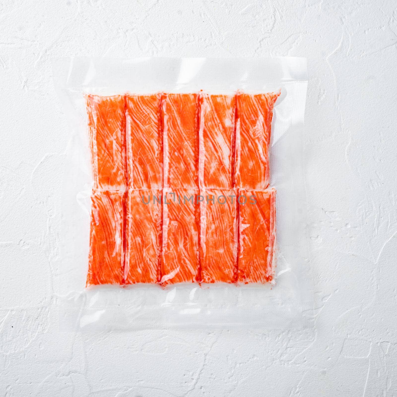 Crab fish meat sticks in vacuum pack, on white background, top view flat lay by Ilianesolenyi