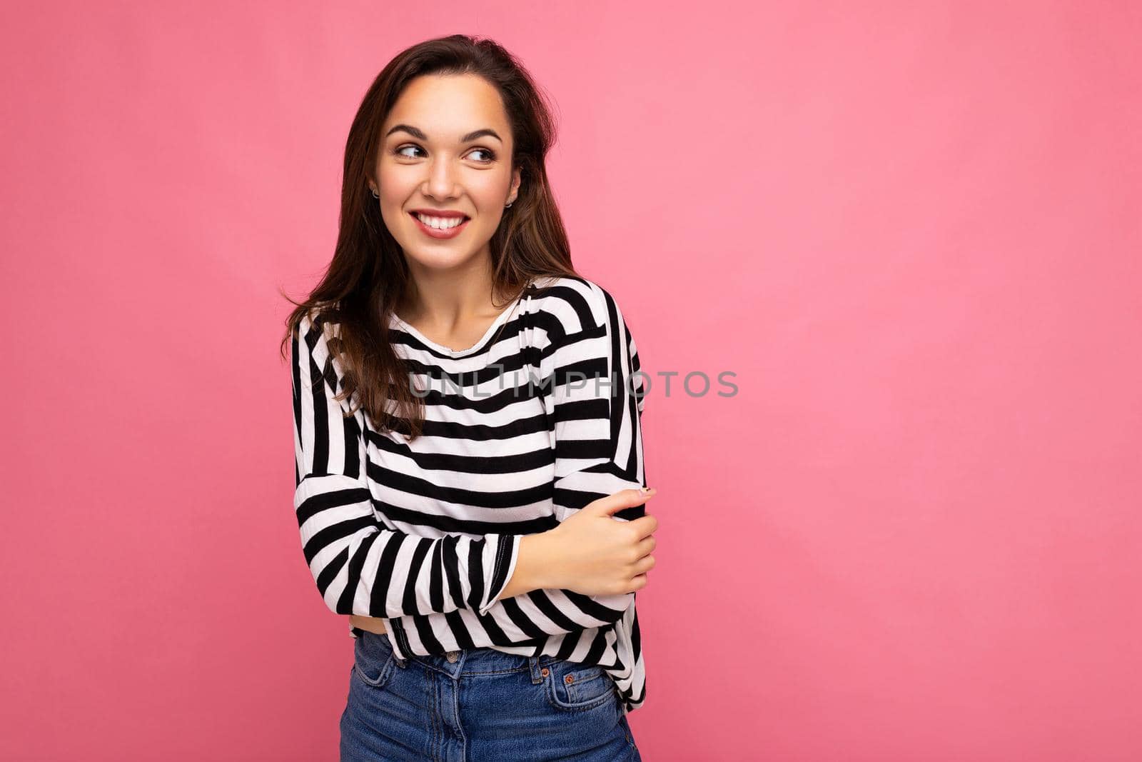 Portrait of positive cheerful fashionable woman in casual clothes isolated on pink background with copy space.