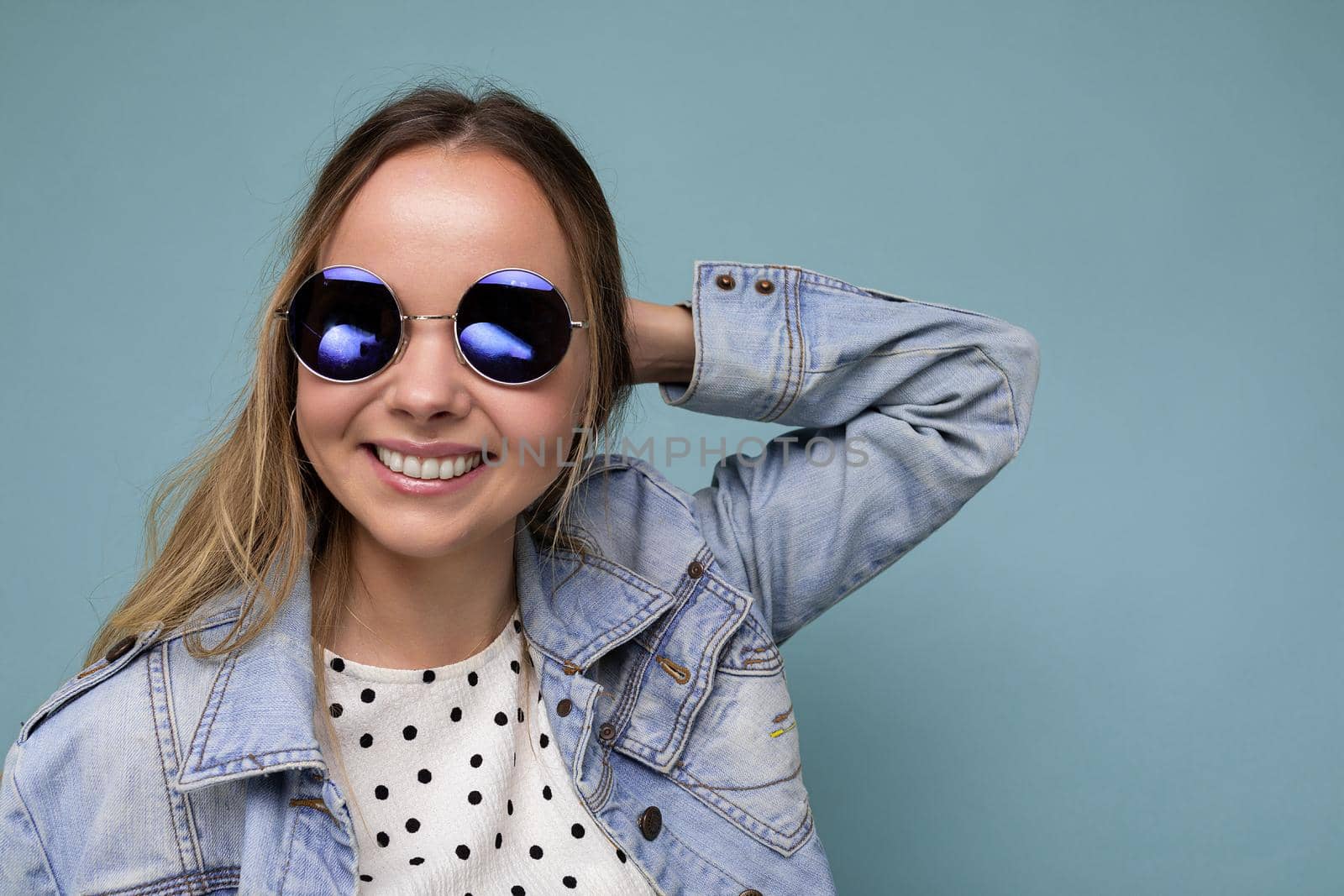 Closeup portrait photo shot of beautiful positive young blonde woman wearing summer casual clothes and stylish sunglasses isolated over colorful background looking at camera.