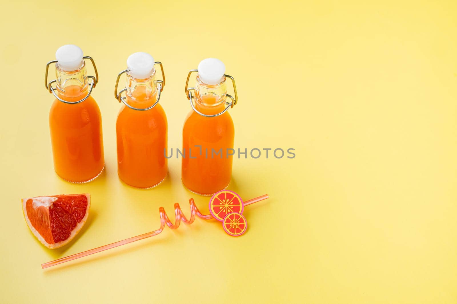 Grapefruit juice set, on yellow textured summer background, with copy space for text