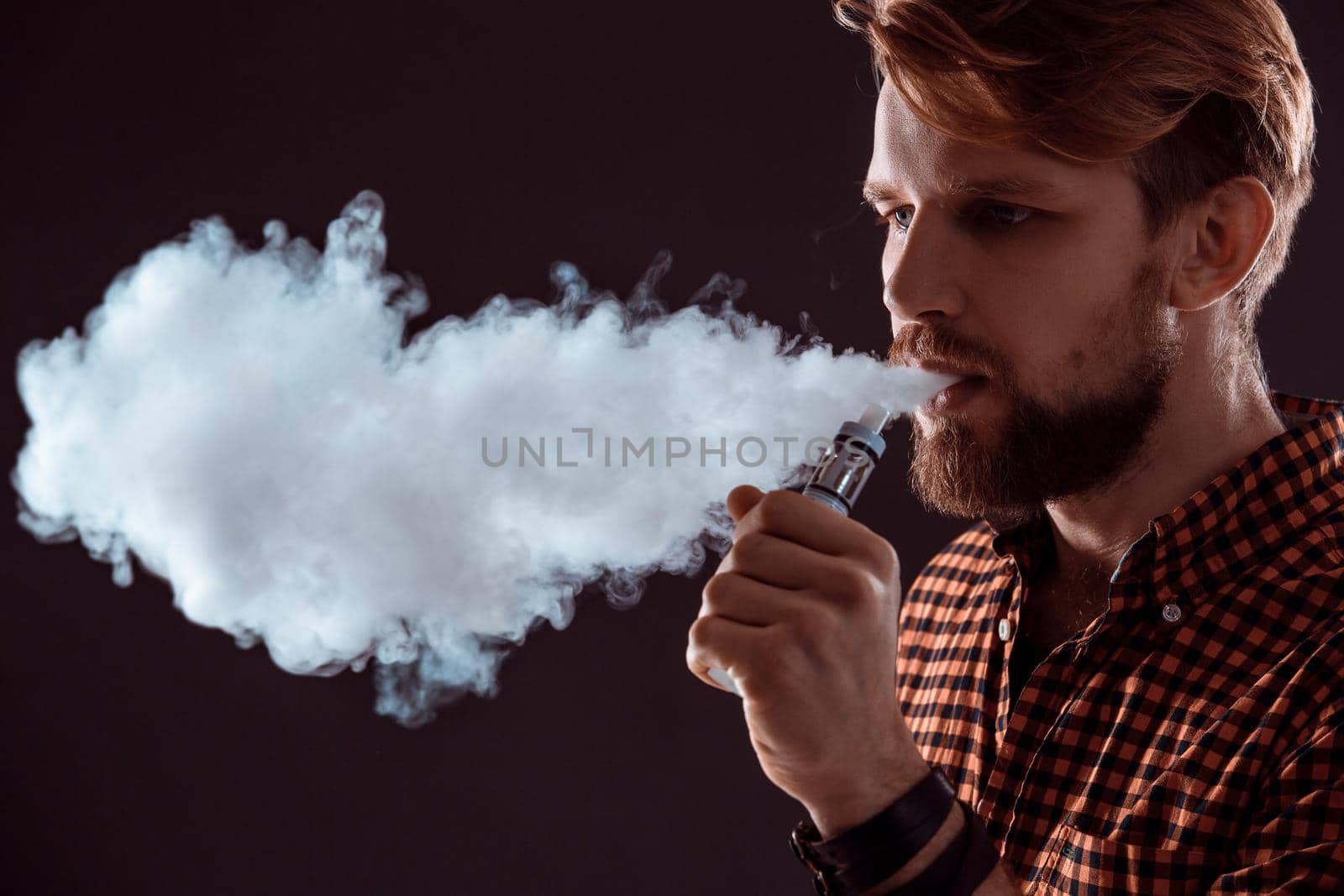 young man smoking electronic cigarette by nazarovsergey