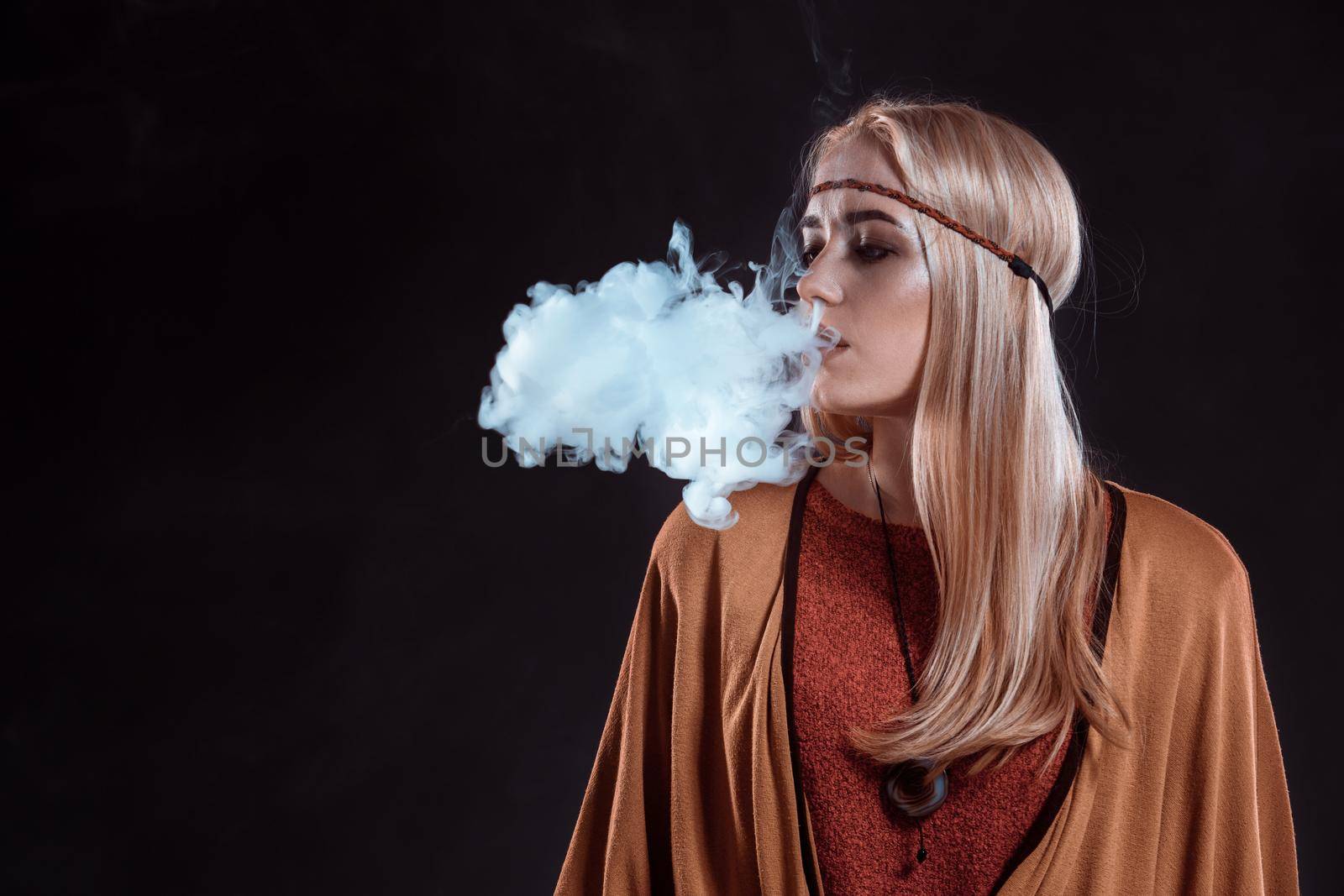 Girl in the Boho style blowing smoke by nazarovsergey