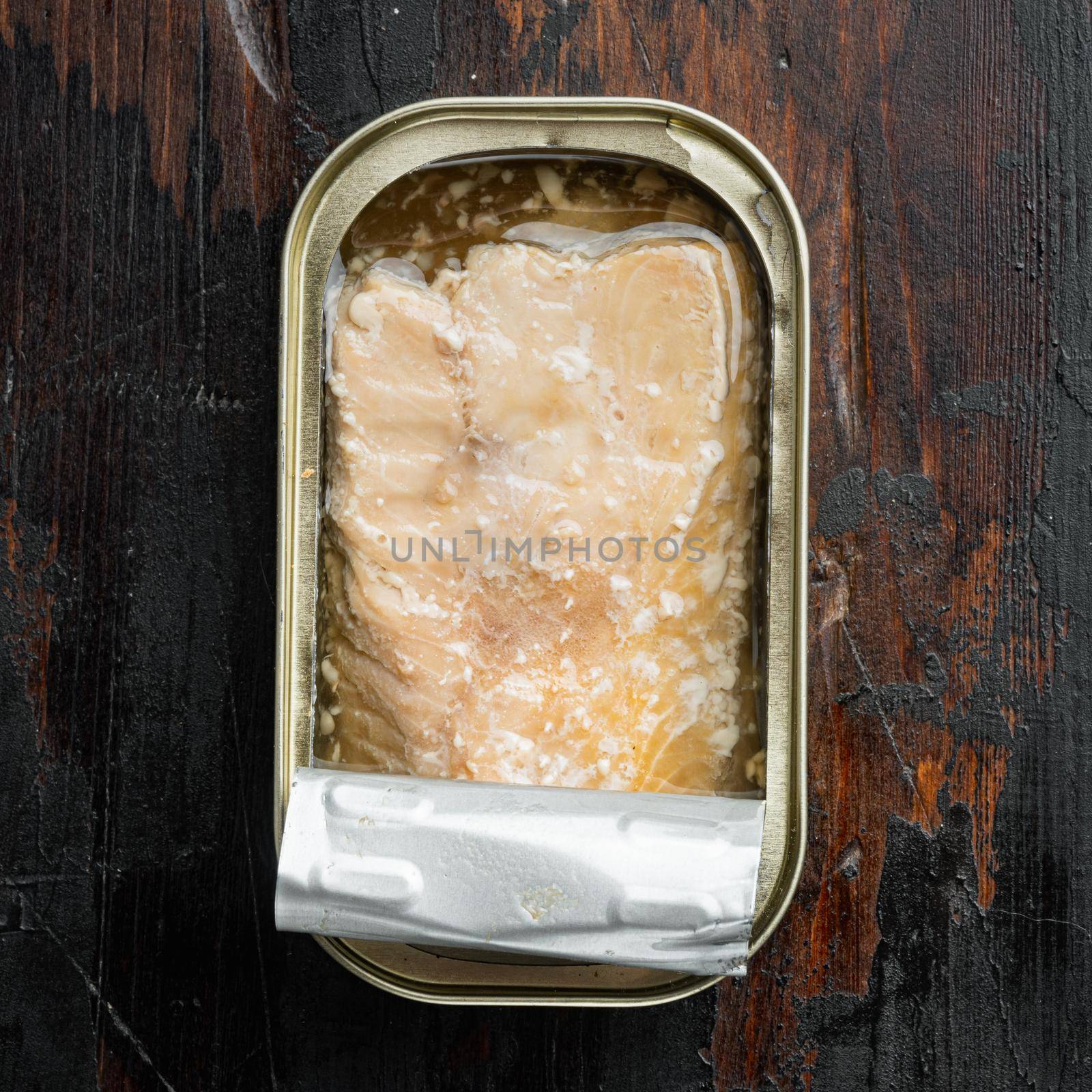 Canned Wild Pink Salmon set, in tin can, on old dark wooden table background, top view flat lay, square format