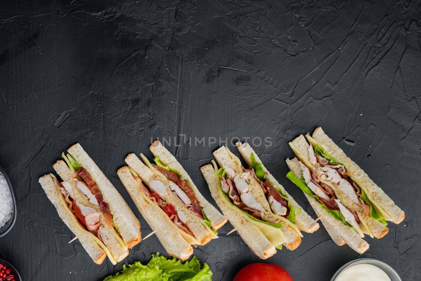Classic club sandwich with meat, on black background, top view with copy space for text