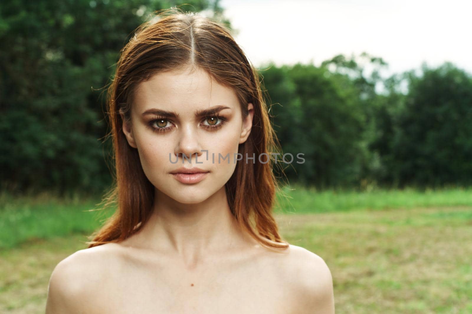 pretty woman in a field outdoors bare shoulders clear skin cropped view. High quality photo