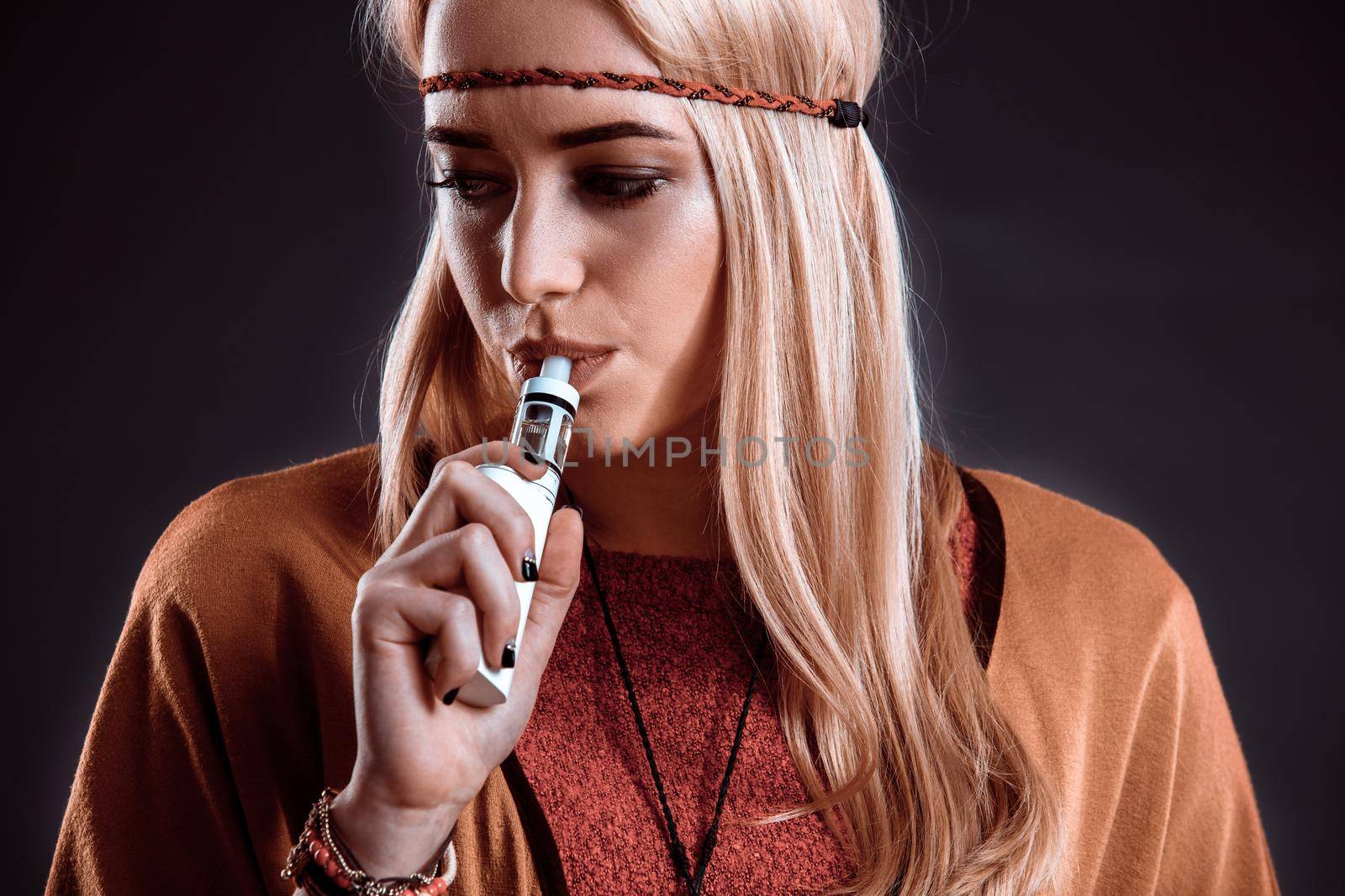 Young woman in the Boho style blowing smoke by nazarovsergey