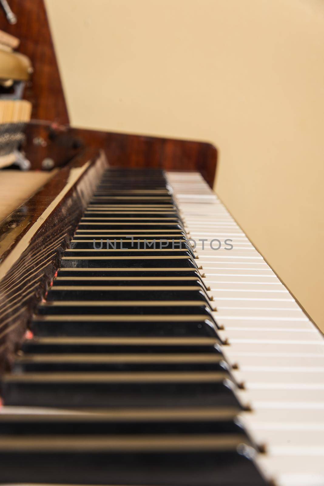 Piano keyboard background with selective focus. Warm color toned image by zartarn