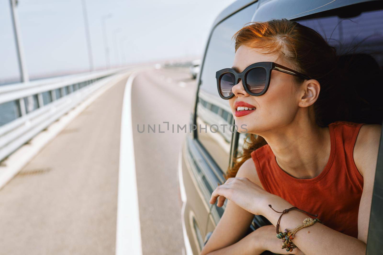 woman looking out of car window wearing sunglasses travel lifestyle. High quality photo