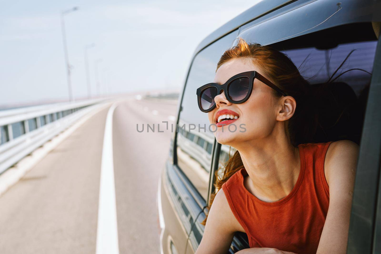 woman looking out of car window wearing sunglasses travel lifestyle. High quality photo