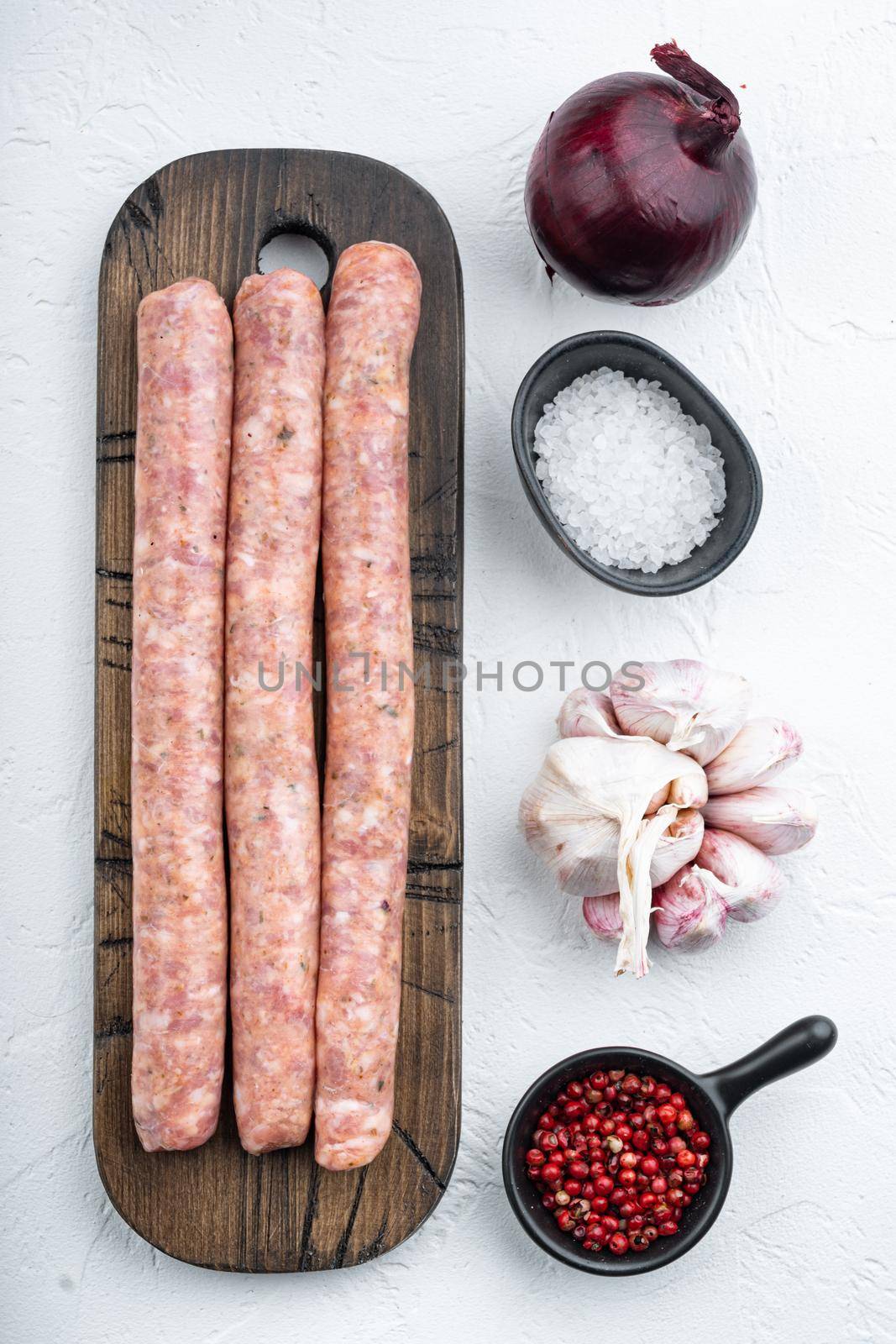 Homemade beef sausages, top view, on white background.