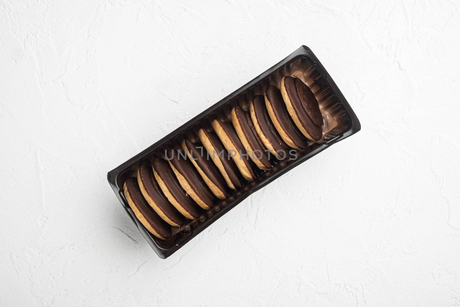 Polish chocolate chip cookies for dessert set, in plastic tray container, on white stone table background, top view flat lay, with copy space for text