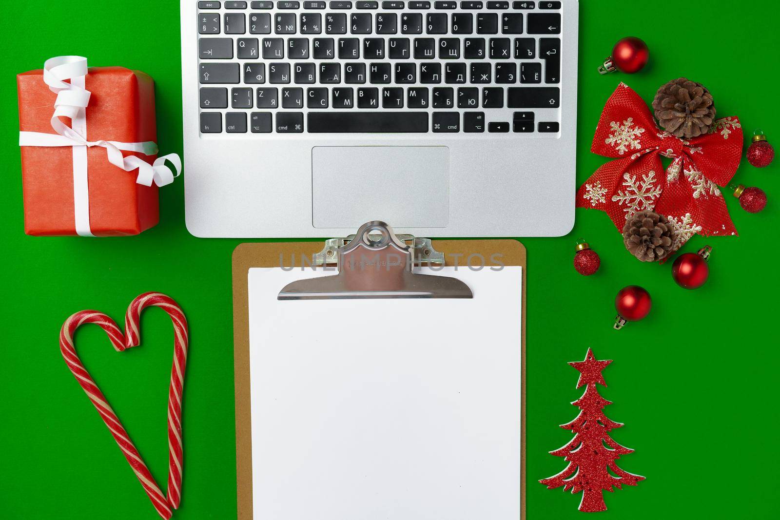 Christmas decorations and computer laptop on paper background top view
