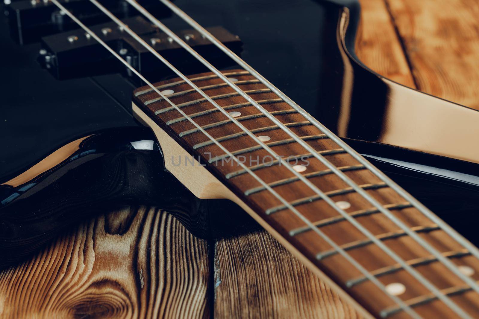 Close up photo of electric guitar fingerboard on dark background