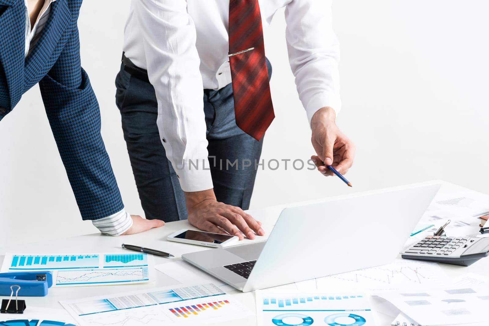 Businesspersons stand near desk with financial charts. Manager use laptop computer for presentation. Estimation and analyze of new startup project. Corporate teamwork concept with business people