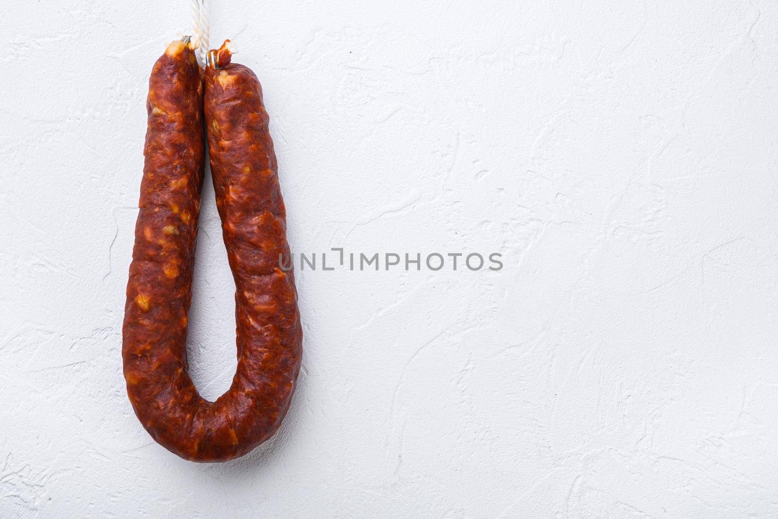 Spanish chorizo sausage on white background, topview with space for text.